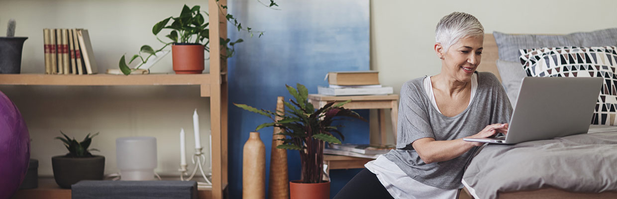 Smiling woman writing on a book; image used for Online Banking.